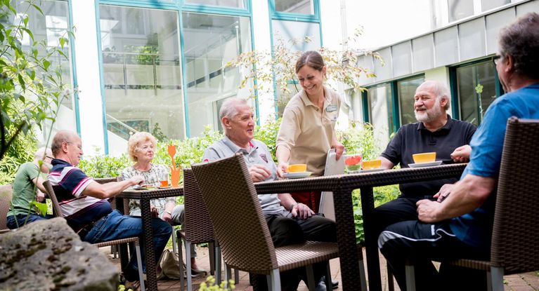 Freizeit Eine Gruppe sitzt im Außenbereich der Deister Weser Klinik und trinkt Kaffee