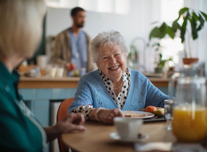 Ältere Frau freut sich beim Frühstück