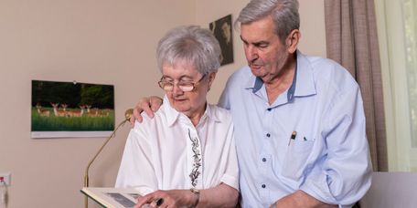 Älteres Paar blättert gemeinsam in einem Fotoalbum